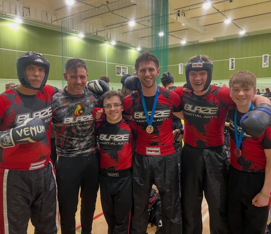 Blaze Martial Arts instructor, Cyrus with the kickboxing fight team at a competition